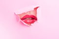 Cute woman mouth wearing red gloss thru ripped paper hole Royalty Free Stock Photo