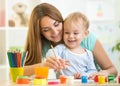 Cute woman playing and painting with child