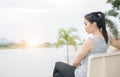 Cute woman sit on chair near lake with sunrise. Royalty Free Stock Photo