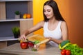 Cute woman slices cucumber for diet salad. Royalty Free Stock Photo