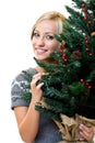Cute woman smiling and holding a christmastree Royalty Free Stock Photo