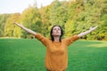 Cute woman standing in spring nature park with wide open arms raised up Royalty Free Stock Photo