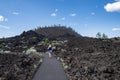Cute woman takes a hike along the Trail of Molten Lands in Lava Lands Newberry Volcano National Monument in Oregon