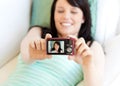 Cute woman taking picture of herself lying on bed Royalty Free Stock Photo