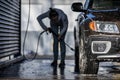 Cute woman washing her car in a manual carwash