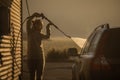 Cute woman washing her car in a manual carwash