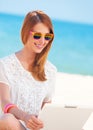 Cute woman with white laptop on the summer beach Royalty Free Stock Photo