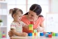 Cute woman and kid playing educational toys at kindergarten or nursery room Royalty Free Stock Photo