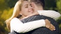 Cute woman tenderly embracing husband, romantic date outdoors, feeling love