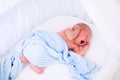 Cute yawning newborn baby in white bed Royalty Free Stock Photo