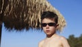 Cute 5 year old Caucasian boy poses on a beach