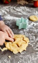 A cute 3-4 year old girl makes her own Christmas cookies. Family vacation at home during the holidays. Flour and dough Royalty Free Stock Photo