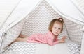 Lovely 2 years little girl lying in wigwam tent at home