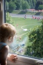 A cute 2 years old baby boy watching a soccer or a football game from his window. Sport fan Royalty Free Stock Photo