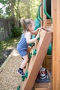 Cute 2 - 3 years old toddler child having fun trying to climb on artificial boulders