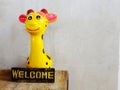 Ceramic giraffe with welcome sign on wooden background Royalty Free Stock Photo