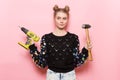 Cute young adult woman holding working tools in hands.