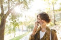 Cute young amazing woman walking outdoors in park in beautiful spring day talking by mobile phone Royalty Free Stock Photo