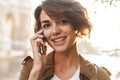 Cute young amazing woman walking outdoors in park in beautiful spring day talking by mobile phone Royalty Free Stock Photo