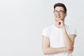 Cute young ambitious male freelancer in glasses with brislte daydreaming, looking left as enjoying view or thinking Royalty Free Stock Photo