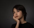 Cute young asian boy looking up with serious look on black background Royalty Free Stock Photo