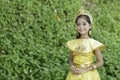 A cute young Asian elementary school student wore a golden traditional Thai costume