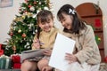 A cute young Asian girl is enjoying talking with her younger sister while having fun on Christmas Royalty Free Stock Photo