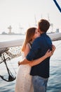Cute young beautiful couple hugging at pier at port with small yachts, hipsters Royalty Free Stock Photo