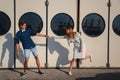 Cute young beautiful couple kidding at port, on the white wall with big portholes background, happy smiling outdoor portrait