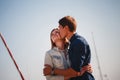 Cute young beautiful couple at pier at port with small yachts, hipster, happy smiling outdoor portrait Royalty Free Stock Photo