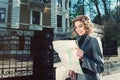 Cute young beautiful curly smiling caucasian travelling woman reading a map