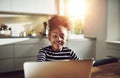 Cute young black girl playing on a laptop