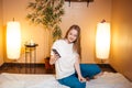 Cute blonde woman using a smartphone while waiting massage at spa