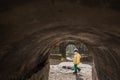 A cute young boy child is playing outside in old fort tunnel in a cold sunny day