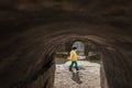 A cute young boy child is playing outside in old fort tunnel in a cold sunny day