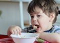 cute young boy eating healthy oatmeal for breakfast Royalty Free Stock Photo