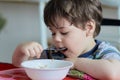 cute young boy eating healthy oatmeal for breakfast Royalty Free Stock Photo