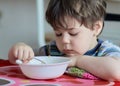 cute young boy eating healthy oatmeal for breakfast Royalty Free Stock Photo