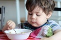 cute young boy eating healthy oatmeal for breakfast Royalty Free Stock Photo