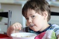 cute young boy eating healthy oatmeal for breakfast Royalty Free Stock Photo