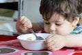 cute young boy eating healthy oatmeal for breakfast Royalty Free Stock Photo