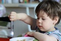 cute young boy eating healthy oatmeal for breakfast Royalty Free Stock Photo