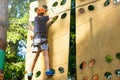 Cute young boy in helmet with climbing equipment in the rope amusement park. Summer camp, holidays Royalty Free Stock Photo