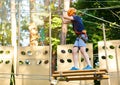 Cute young boy in helmet with climbing equipment in the rope amusement park. Summer camp, holidays Royalty Free Stock Photo