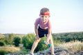 Cute Young Boy Lifting Dumbbell on Top of Boulder