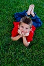 Cute young boy lying in the grass