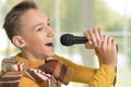 Cute young boy singing into a microphone Royalty Free Stock Photo