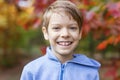 Cute young boy smiling on walk in autumn park Royalty Free Stock Photo