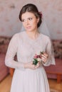 Cute young bride at home in white wedding dress, preparations concept. Portrait of tender girl in gown Royalty Free Stock Photo