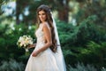 Cute young bride with long hairs holding her wedding bouquet includes white roses and other flowers. Beautiful white Royalty Free Stock Photo